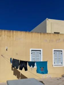 Sepia yellow home with blue coloured clothes hanging outside the house