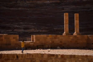 Child wearing a yellow jumper, walking across Jordan's ancient grounds