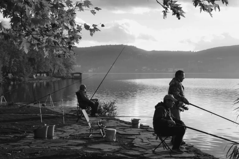 Group of three fishermen fishing fish at a lake