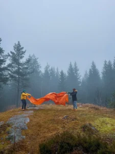 Two boys fixing their tent in a stunning, cold and atmospheric natural landscape