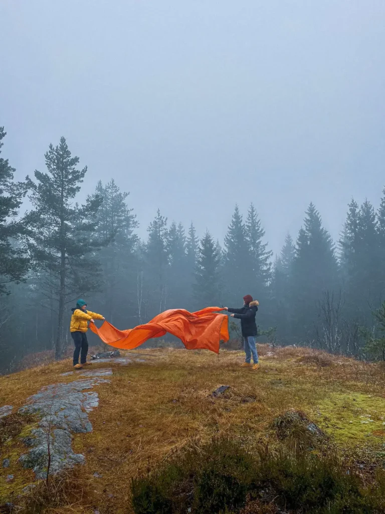 Two boys fixing their tent in a stunning, cold and atmospheric natural landscape